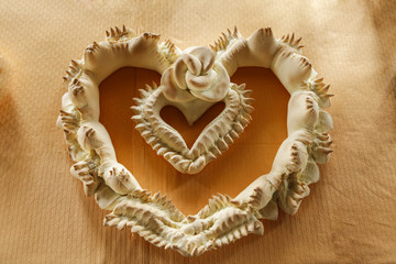 Pane tipico della sardegna detto coccoi preparato a festa a forma di cuore su sfondo chiaro