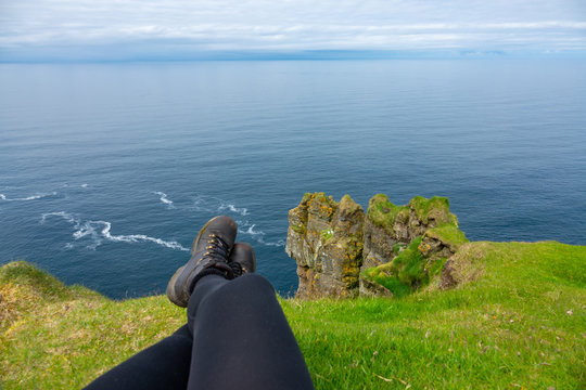 POV: Sitting On The Grassy Edge Of A Cliff And Looking At The Ocean Below You.