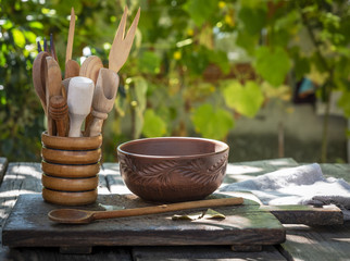 empty clay plate and various wooden kitchen objects
