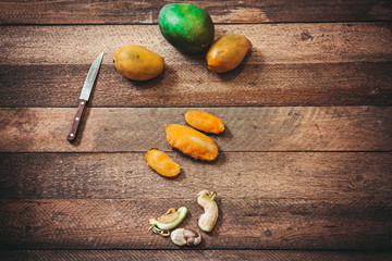 Ripe mangoes with bones on wooden board