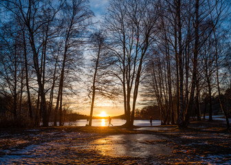 Man running and woman taking a photo of sunset