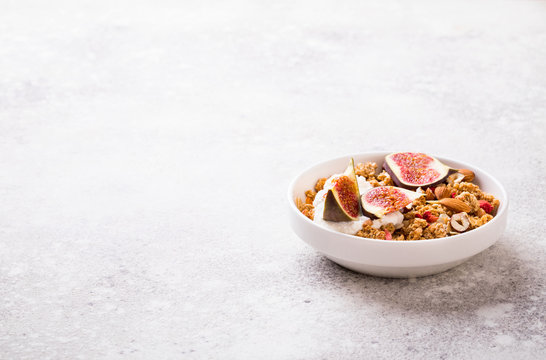 Muesli with Nuts Yogurt and fresh Figs on the gray Background.Granola Healthy Breakfast. Sweet food Dessert. Snack  Dry Diet Nutrition Concept.Copy space for Text