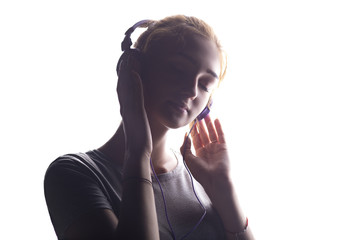 romantic girl listening to music in headphones, young woman relaxing on a white isolated background