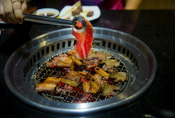 Beef slice grilled on yakiniku stove which has hot charcoal. Barbecue Japanese style. image for background, copy space and backdrop.