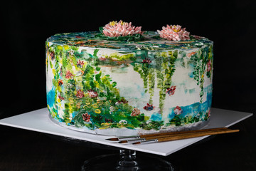 Hand painting buttercream water lilies cake. Homemade baking. Decorating cream cake with food coloring. Designer Cake. Selective focus. Horizontal.