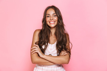 Image of european lovely woman 20s with long hair wearing dress smiling at you with arms crossed, isolated over pink background - obrazy, fototapety, plakaty