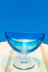 Blue bowl for ice cream on a wooden background of boards