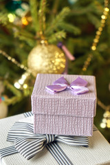 Fototapeta na wymiar Gift boxes with bows on the lids under a Christmas tree in New Year Eve