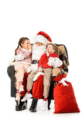 Obraz premium kids whispering to santa while thay sitting in armchair together isolated on white