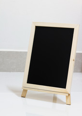 blank slate blackboard on white floor background, copy space.