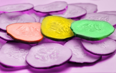 Cucumber slices texture background. pink background. multi-colored cucumbers traffic light