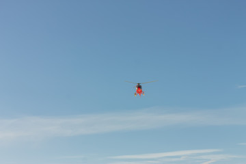 Red rescue helicopter fly in snowy mountains