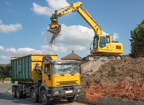 360 excavator loading site clearance materials into a disposal lorry 