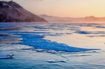 View of beautiful drawings on ice from cracks and bubbles of deep gas on surface of Baikal lake in winter, Russia