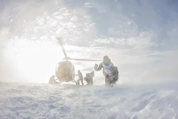 Papier Peint photo Sports dhiver l& 39 atterrissage de l& 39 hélicoptère skieurs freeriders dans les montagnes enneigées en hiver