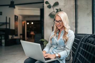 Beautiful blogger working while sitting in the lobby.