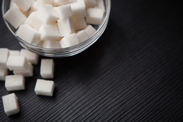 White sugar cubes on black table with copy space, can be used as food background