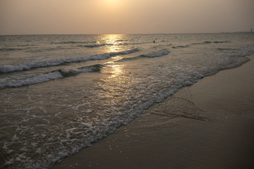 Orange sunset landscape with sea and beach sand. Sun reflection in rippled sea. Romantic evening seascape with sunset.