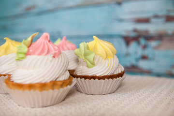 Pink and yellow cupcakes on beautiful blue background, colorful sweet food