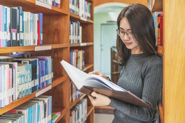 Back to school education knowledge college university concept, Beautiful female college student holding her books smiling happily standing in library, Learning and education concept