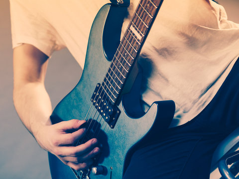 Close up of man playing on electric guitar
