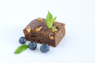 Brownie on white background with blueberries.
