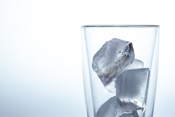Cubes of ice in the double glass close up on white background.