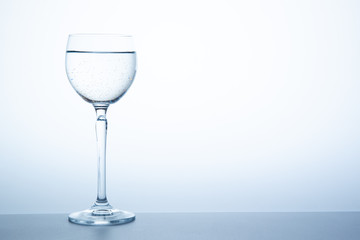 Water in the luxury wine glass close up.  Concept of good healthy and refreshment.  Copy space on right side on the image.