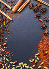 Spices and herbs on a dark background (top view), place for inscription, template for text
