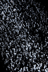 Drop lets of water splashing in the dark close up.  Concept of the refreshment