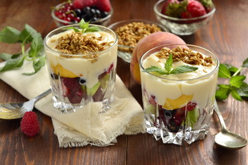 Dessert with fresh berries, granola and custard in glasses