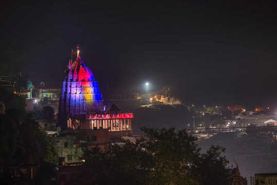 Omkareshwar cityscape by night, India, sacred hindu temple illuminated. Travel destination for tourists and pilgrims.