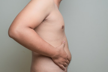 overweight asian men hand holding excessive belly fat