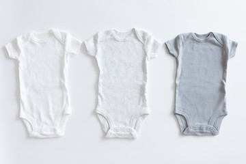 Set of unisex clothing and accessories for a baby in neutral colors, top view and flat lay on white...