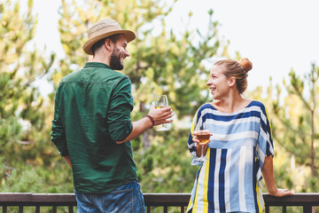 Young couple flirting on the balcony drinking white wine