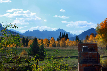An outdoor brick oven in a back yard with an amazing view of mountains and trees in fall colors