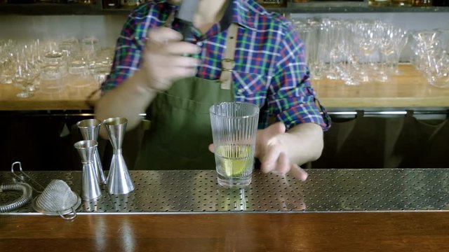 Caipirinha cocktail. The barman preparing an alcoholic drink in a bar. 4K
