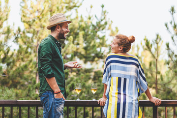 Young couple flirting on the balcony drinking white wine