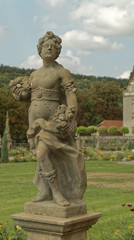 Statue of half-naked goddess with flowers in hand.