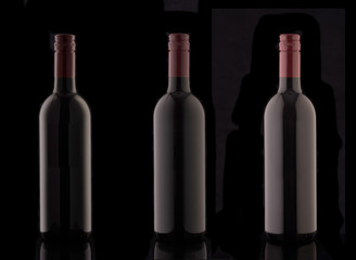 A bottle of red elite wine on a black background. Silhouette of a bottle of wine with a red stopper.