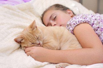 Child with cat sleep on the bed