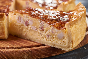 Appetizing cheese cake with sausage, ham. Snack unsweetened cake with crispy cheese crust. An unusual variant of pizza is 