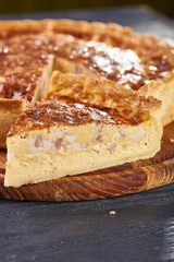 Appetizing cheese cake with sausage, ham. Snack unsweetened cake with crispy cheese crust. An unusual variant of pizza is 