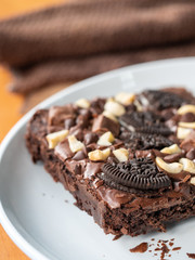 Cookies homemade and cream with chocolate brownies and almond on white dish