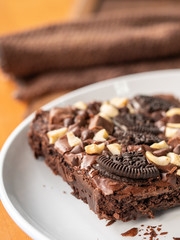 Cookies homemade and cream with chocolate brownies and almond on white dish