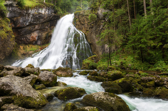 Beautiful view of famous Gollinger Wasserfall with mossy rocks and green trees on a moody in springtime, Golling, Salzburger Land, Austria