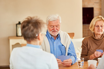 Fototapeta premium Drei Senioren spielen zusammen Karten