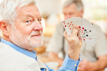 Senior zeigt seine Karten und hat Spaß