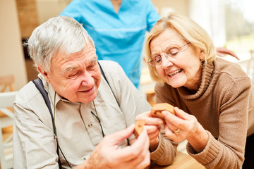 Senioren mit Demenz spielen ein Puzzlespiel