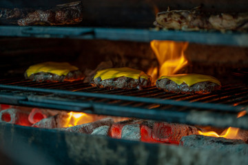 Preparing beef cutlets with cheese on the grill for burgers. Street food. Picnic on the street.